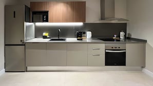Eine moderne Küche mit Backofen, Mikrowelle und Kaffeemaschine.