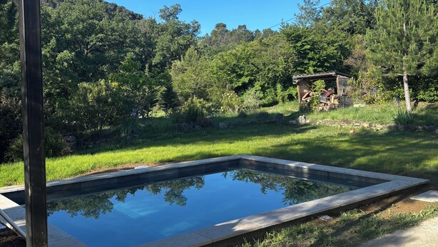 Una piscina con vistas despejadas al follaje circundante y una colina distante.