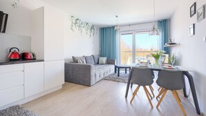 Ein moderner Wohnraum mit Küche, Essbereich und einer Couch.