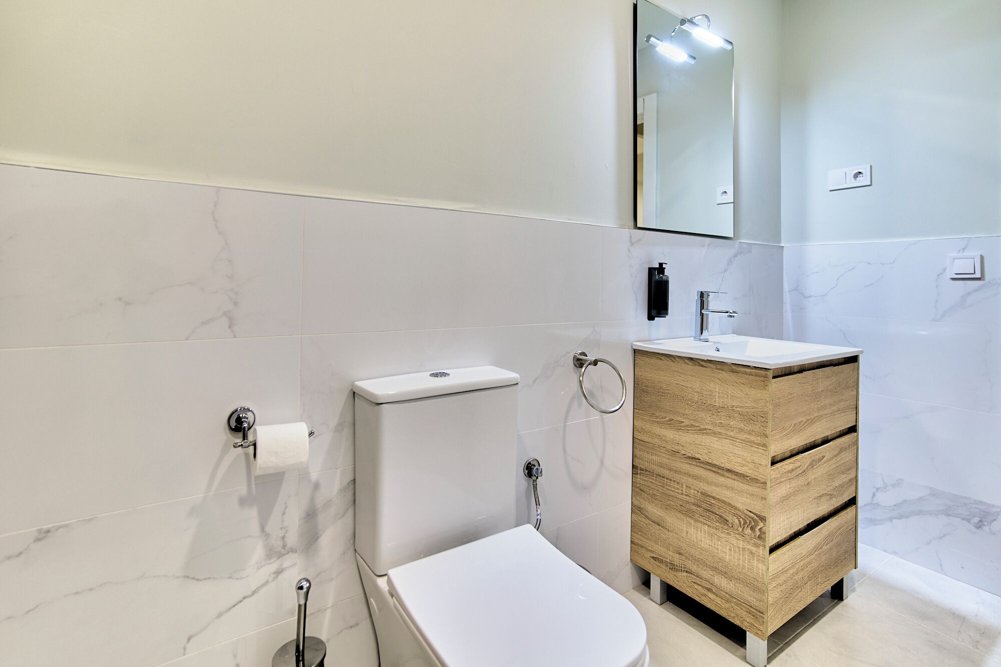 Une salle de bain moderne équipée de toilettes, d’un lavabo et d’un meuble-lavabo.