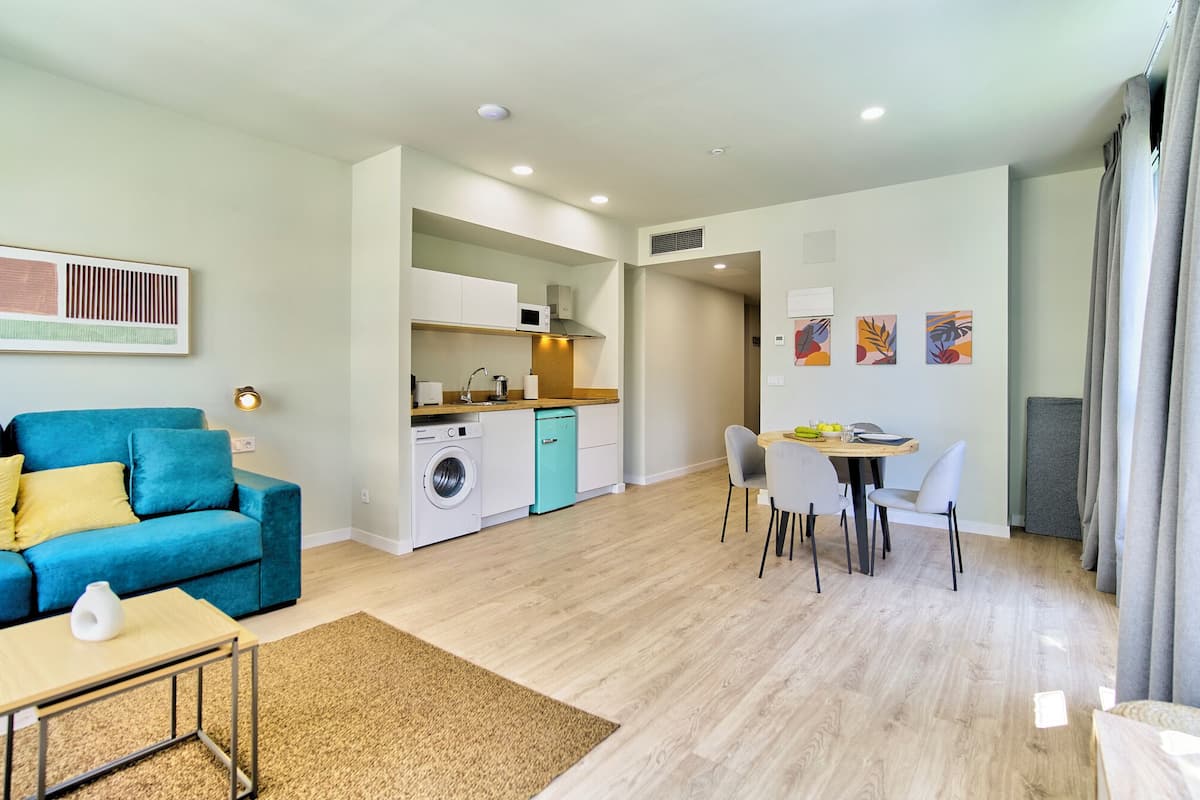 Un appartement moderne comprenant un espace de vie, une cuisine et un coin repas.