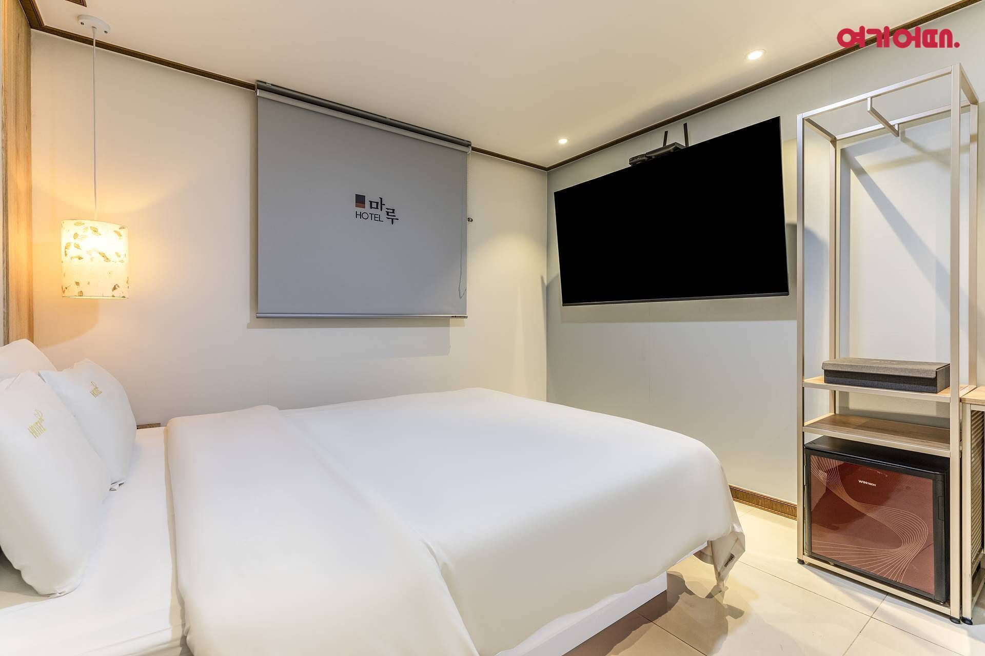 Une chambre d’hôtel équipée d’un lit, d’un téléviseur fixé au mur et d’une cheminée intégrée.