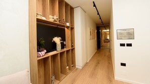 A hallway with wooden shelving units, a welcome sign, and a door leading to a room. - E&K Apartment 02 , Sea view, Free Parking (Vlora)