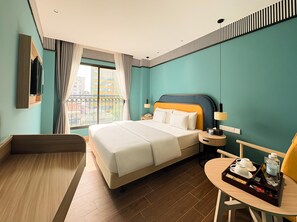 A hotel room with a bed, bedside table, chair, and a small table with a tray. - A25 Premium Hotel - 130 Ba Trieu (Hanoi)