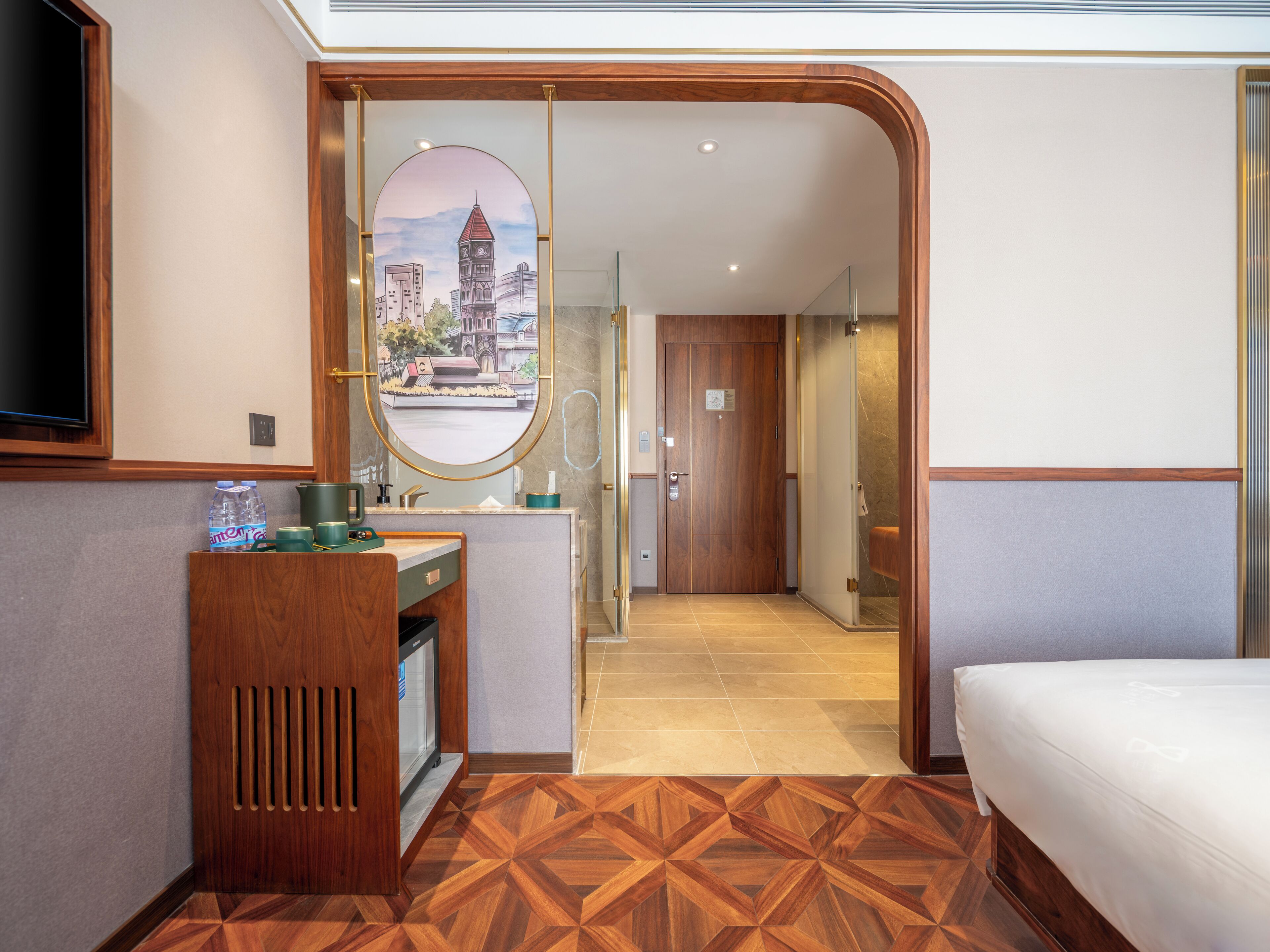 A hotel room with a wooden desk, a mirror, a bed, and a view of a cityscape through a circular mirror.