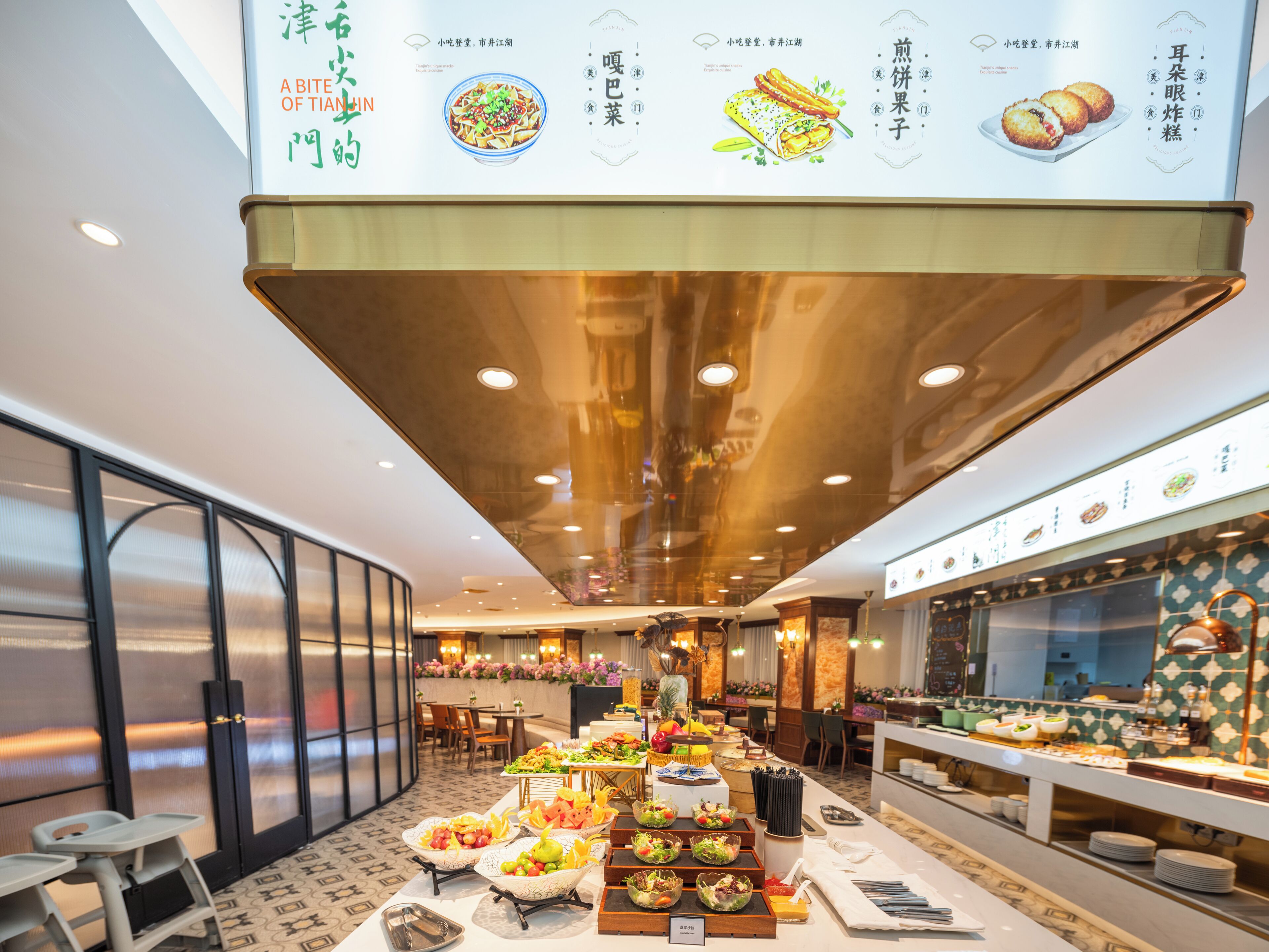 A buffet setup with various food items and a menu board above.