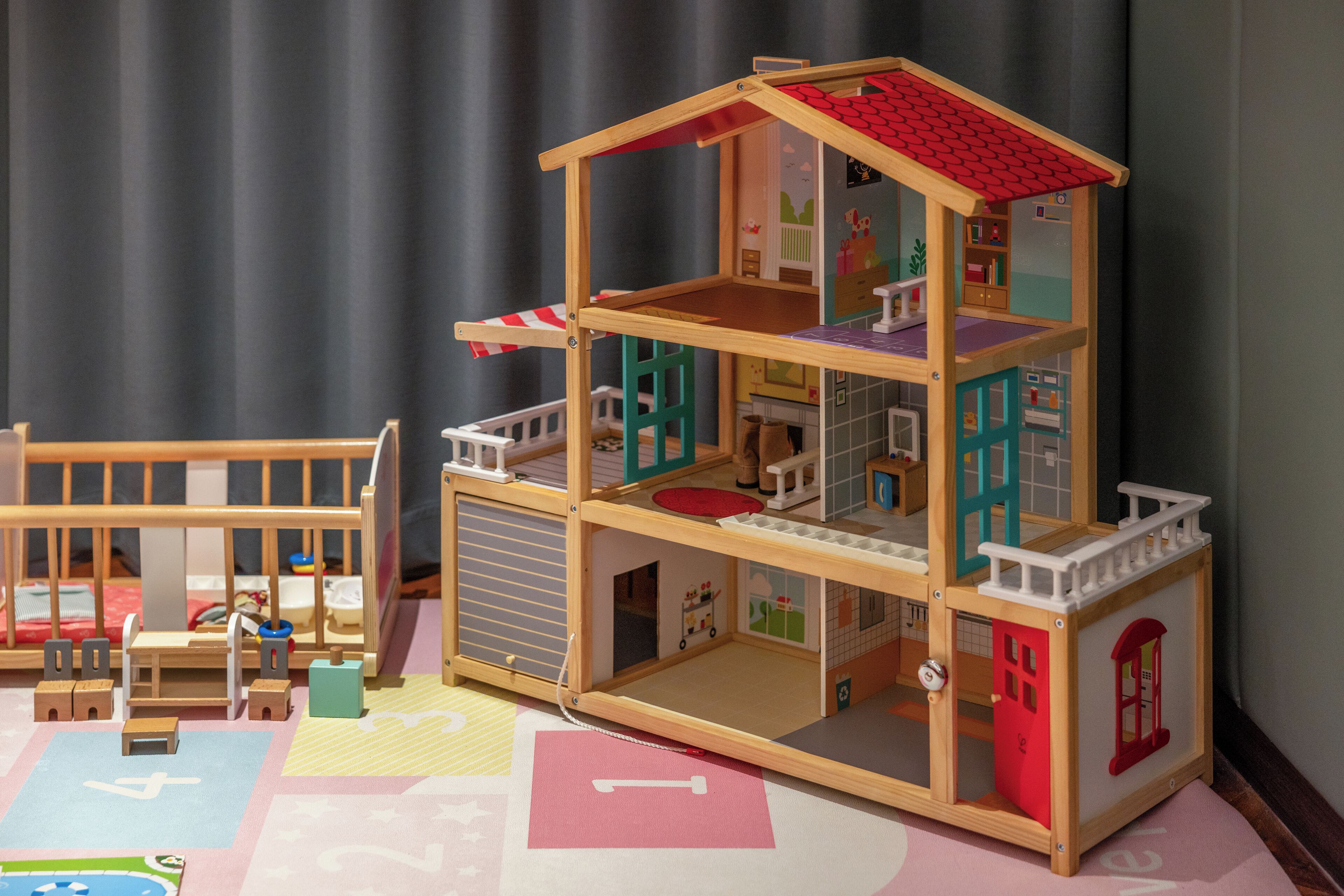 Una casa de muñecas de dos pisos, con balcón y garaje.