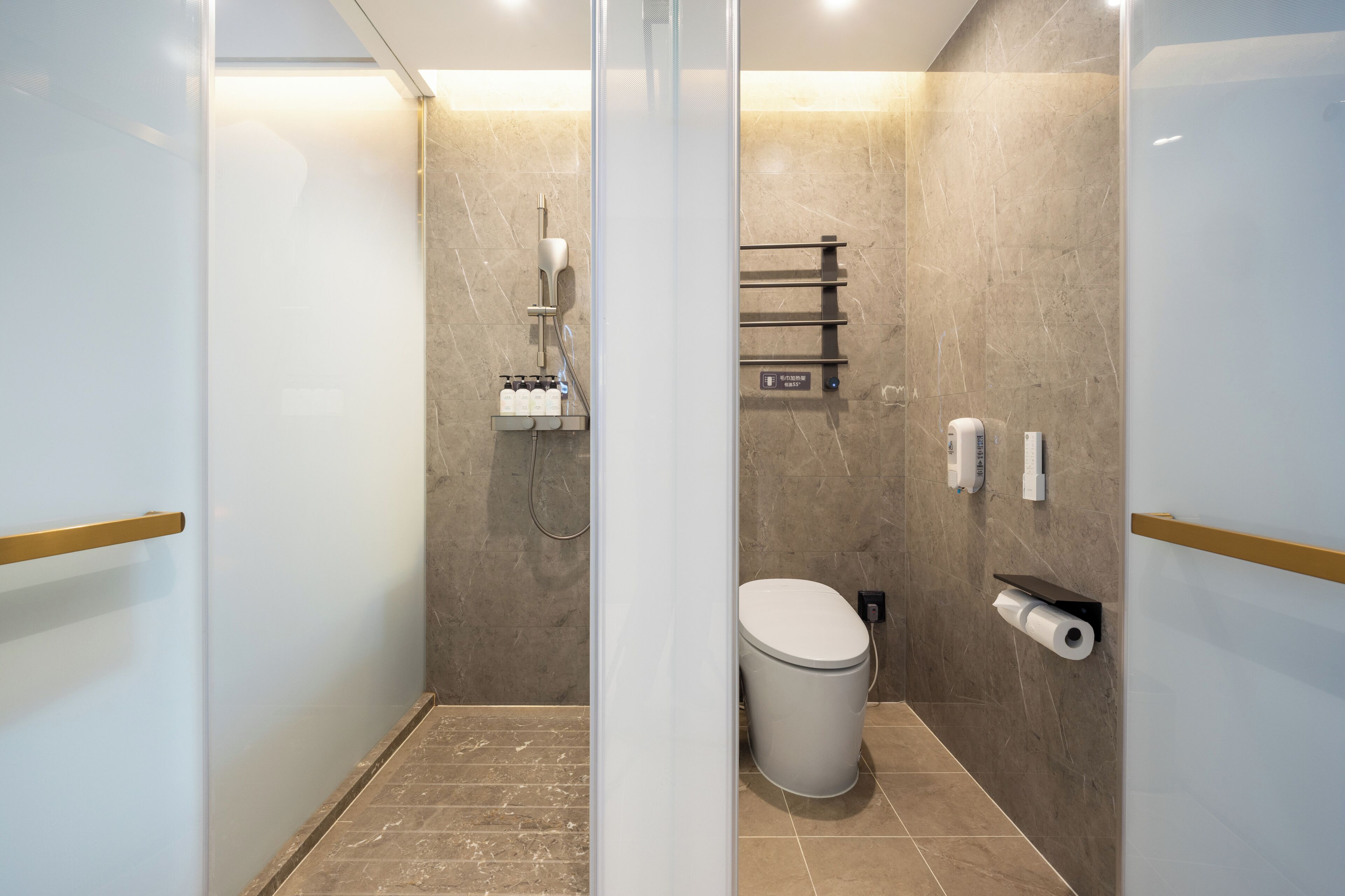 A modern bathroom with a shower, toilet, and towel rack.