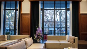 A spacious living area with a sofa set, a coffee table, and a view of the city through large windows. - Nostalgia S Hotel(Tianjin Jinwan Plaza) (Tianjin)
