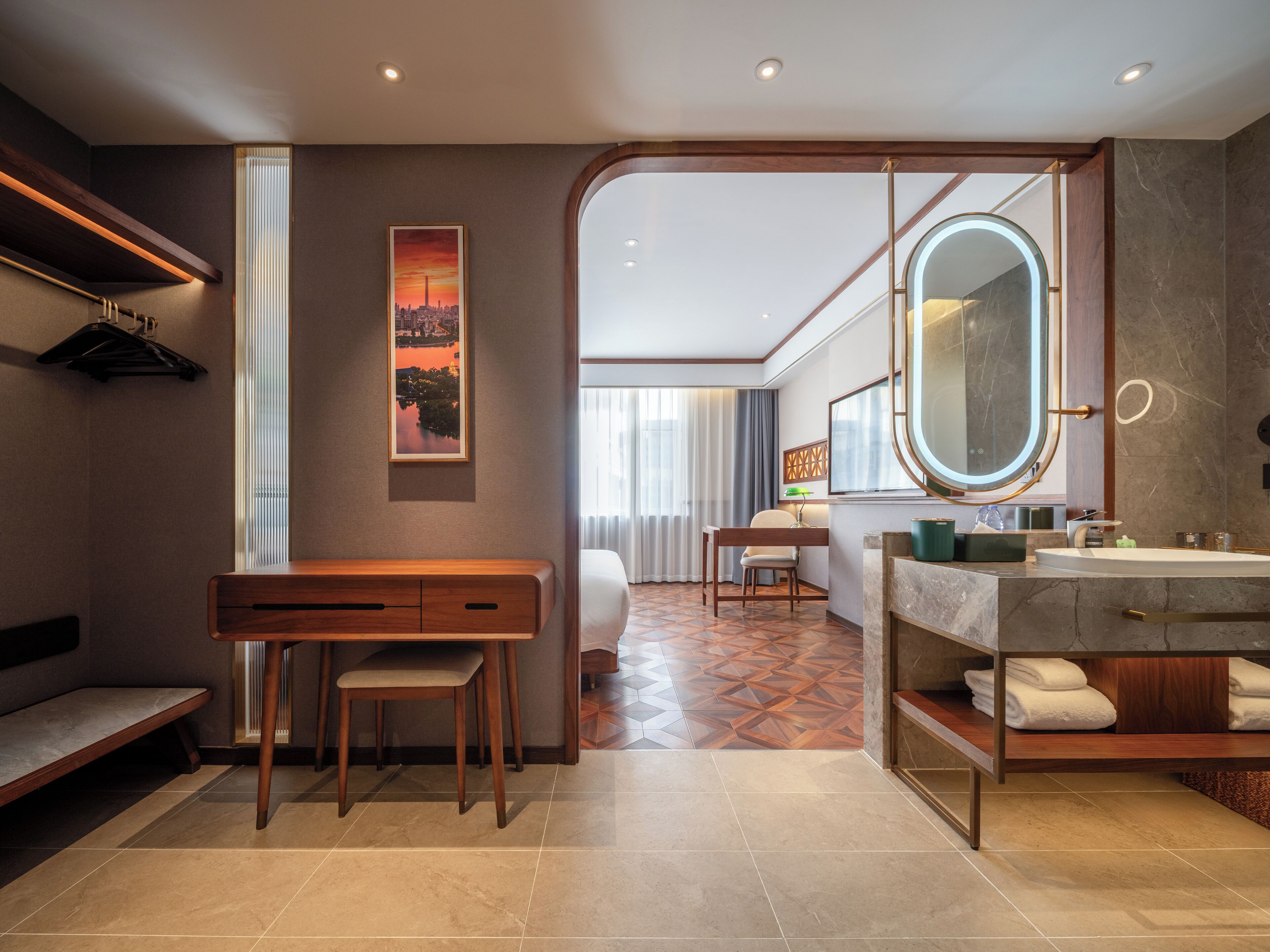 A modern bathroom with a vanity, a large mirror, and a seating area.