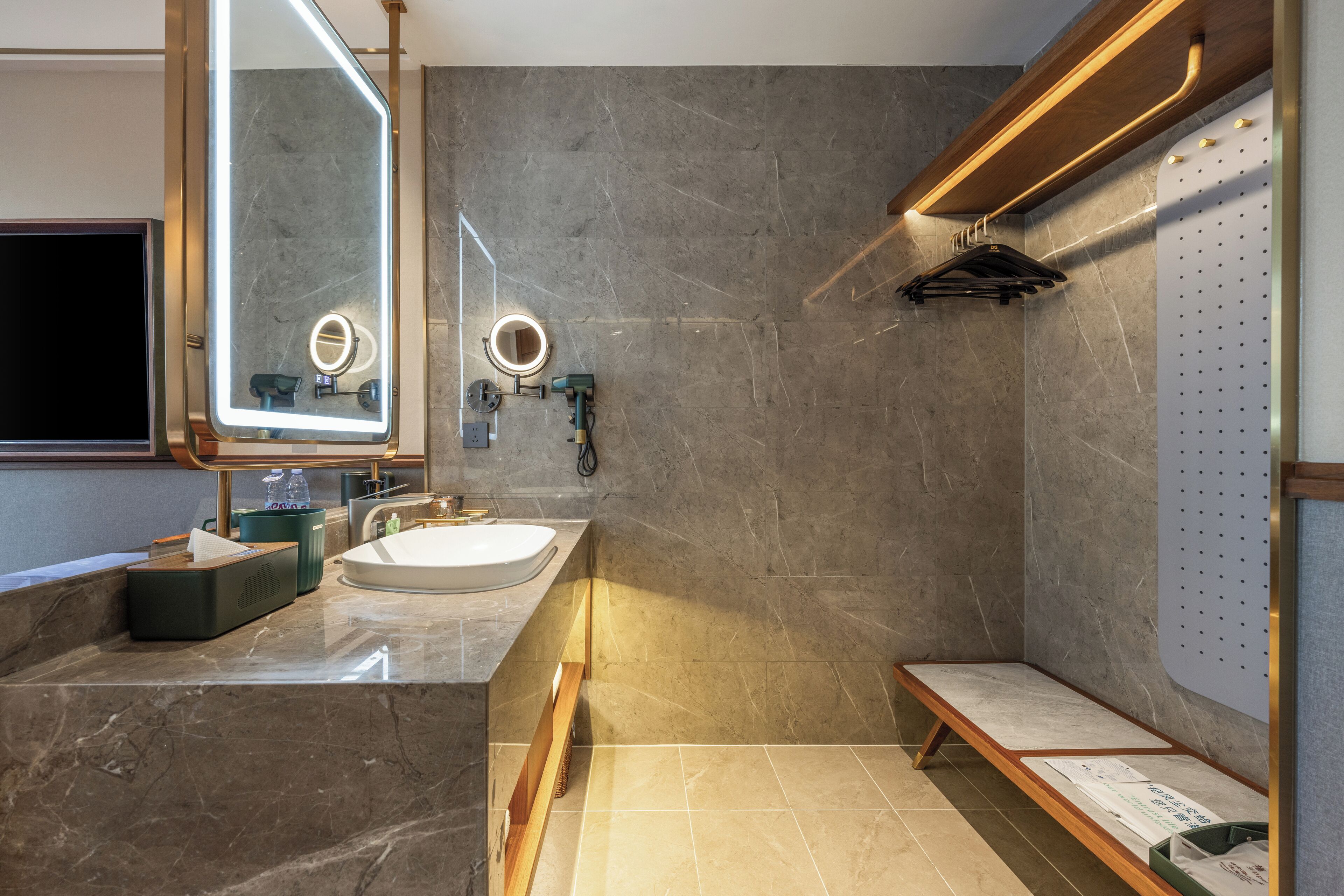 A modern bathroom with a large mirror, a sink, and a shower area.
