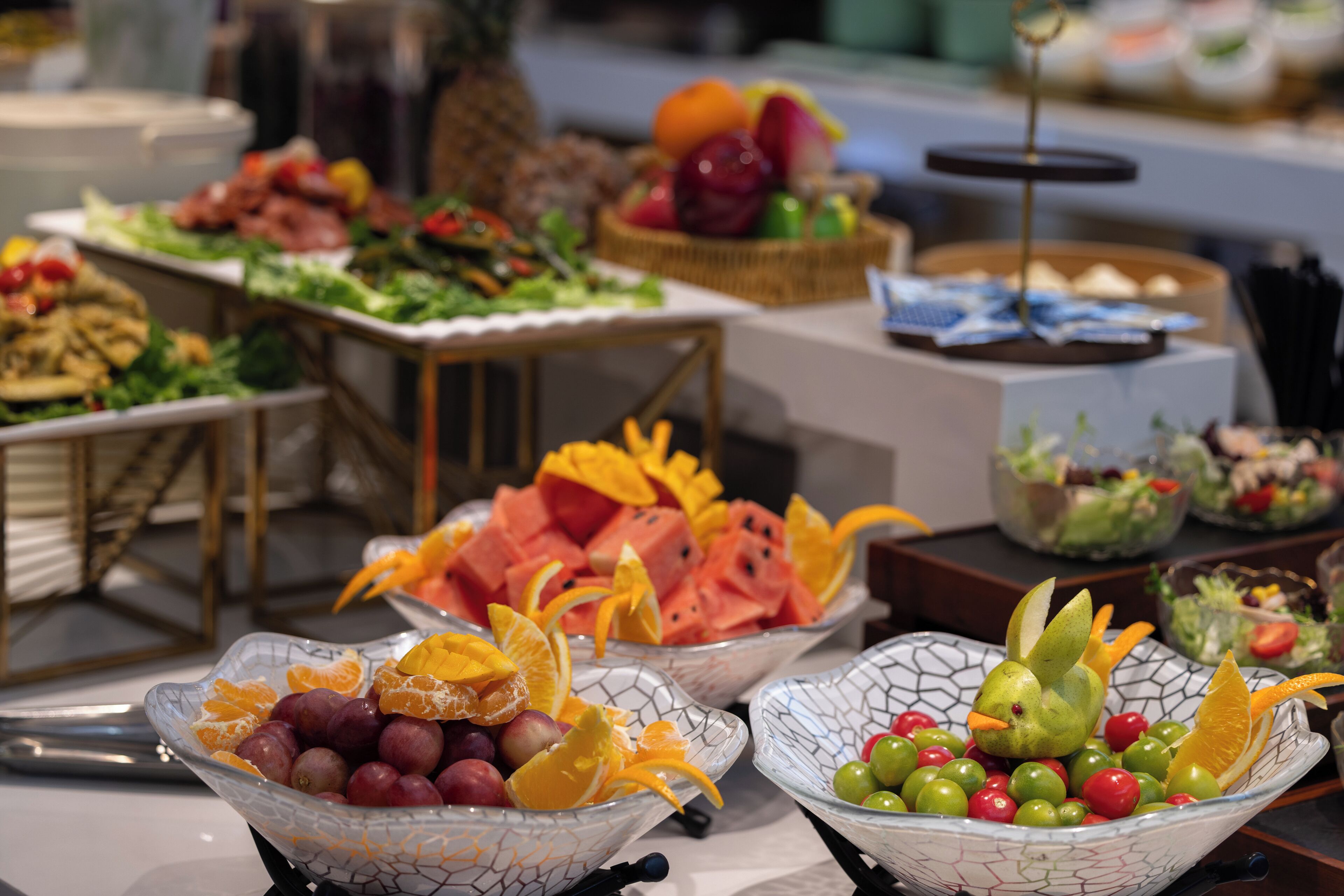 A buffet with various food items including fruits, vegetables, and salads.