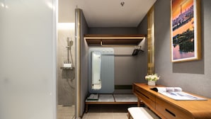 A compact bathroom with a shower, a toilet, a bench, and a vanity with a mirror. - Nostalgia S Hotel(Tianjin Jinwan Plaza) (Tianjin)