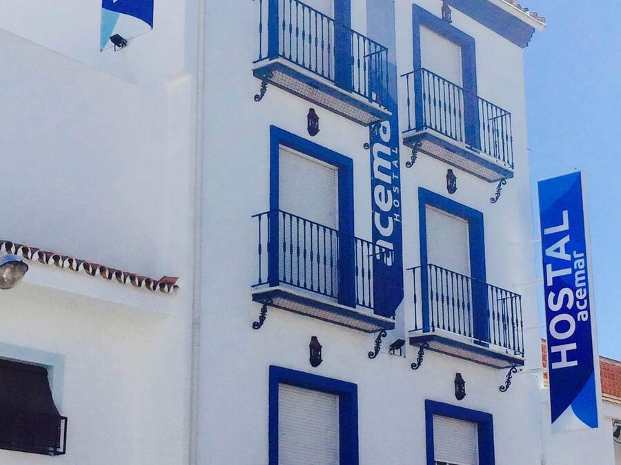 Un bâtiment blanc agrémenté de touches de bleu et doté de balcons, identifié comme une auberge de jeunesse.