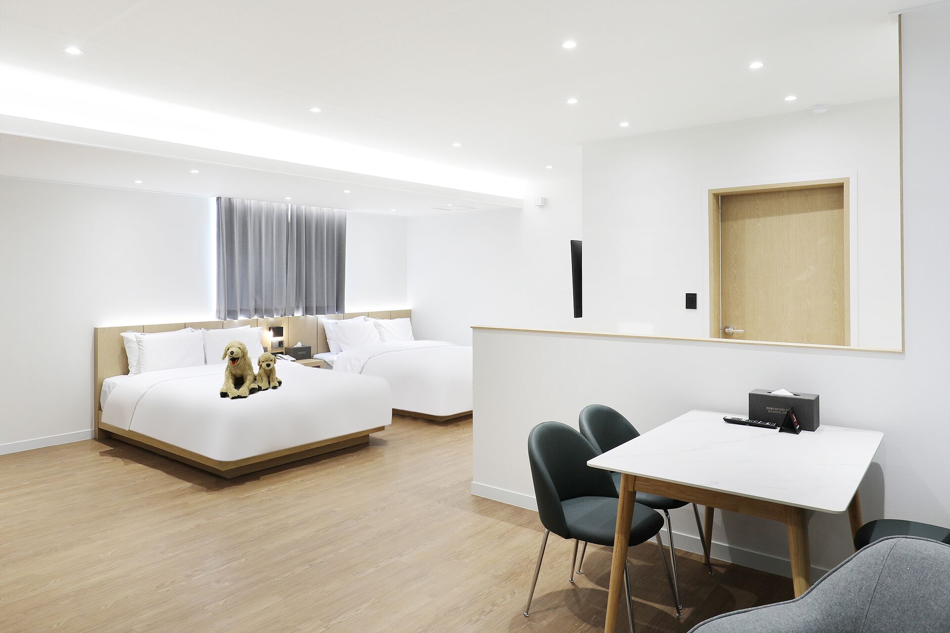 Une chambre d’hôtel moderne avec deux lits, un bureau et une chaise.