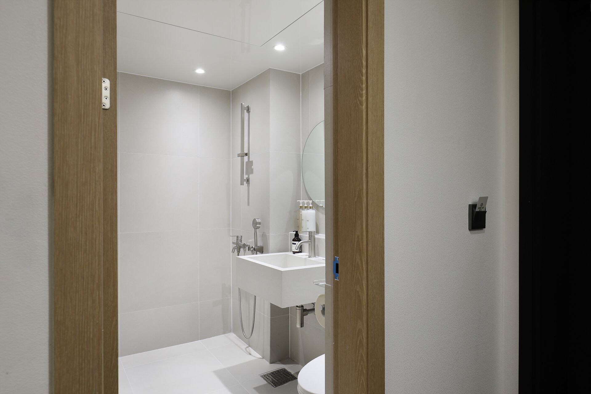 Ein modernes Badezimmer mit einem weißen Waschbecken, Spiegel und WC.