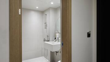 Ein modernes Badezimmer mit einem weißen Waschbecken, Spiegel und WC.