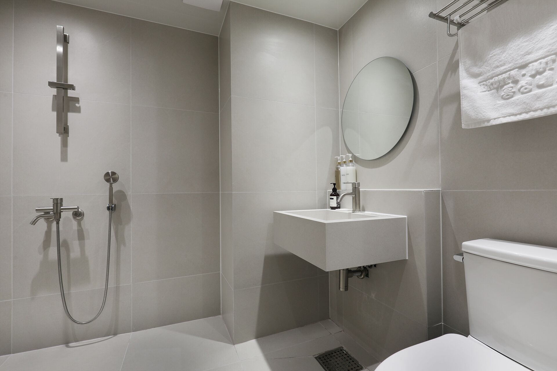 A modern bathroom with a walk-in shower, a sink, and a toilet.