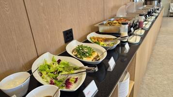 Una barra de buffet amb diferents plats i amanides.