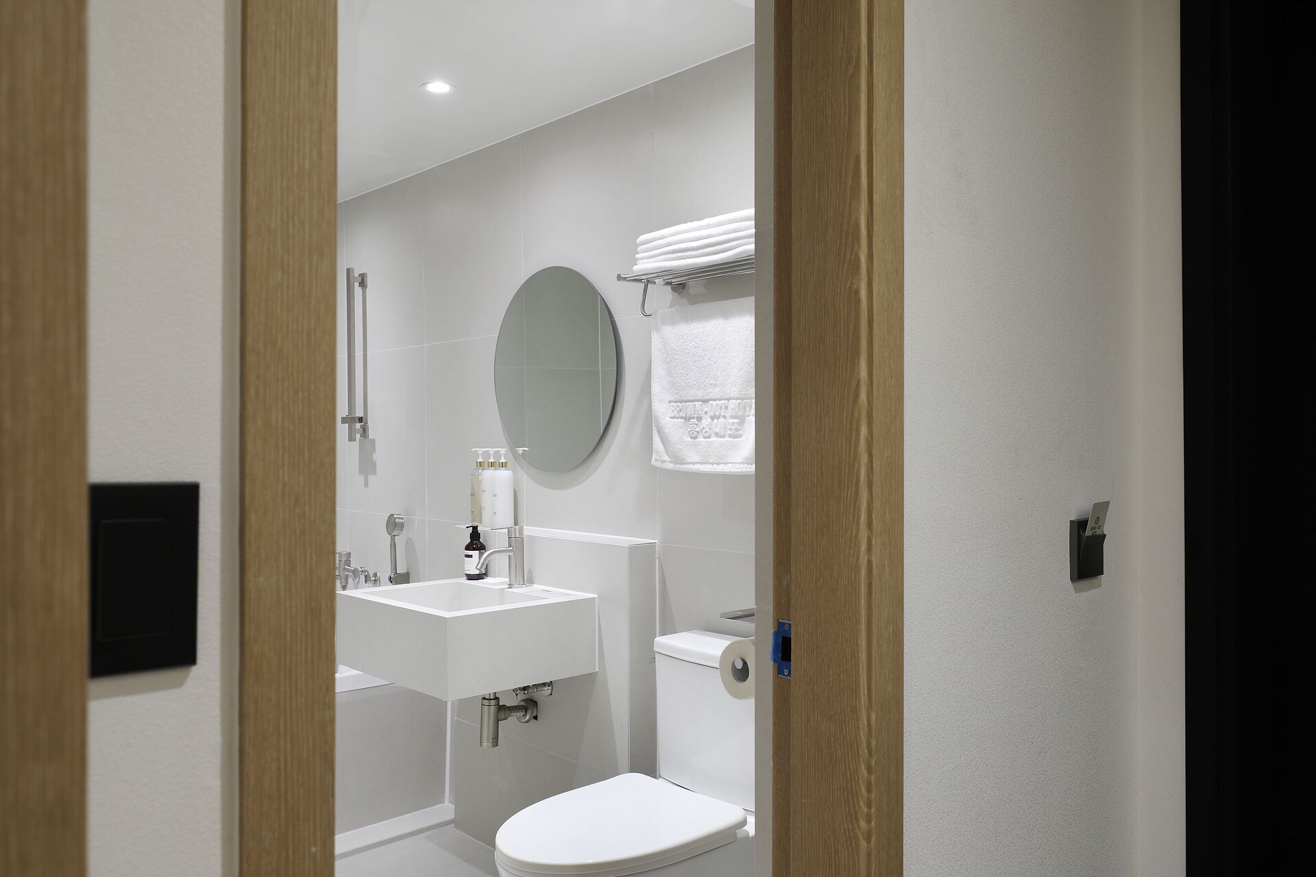A modern bathroom with a toilet, sink, and mirror.