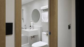A modern bathroom with a toilet, sink, and mirror.