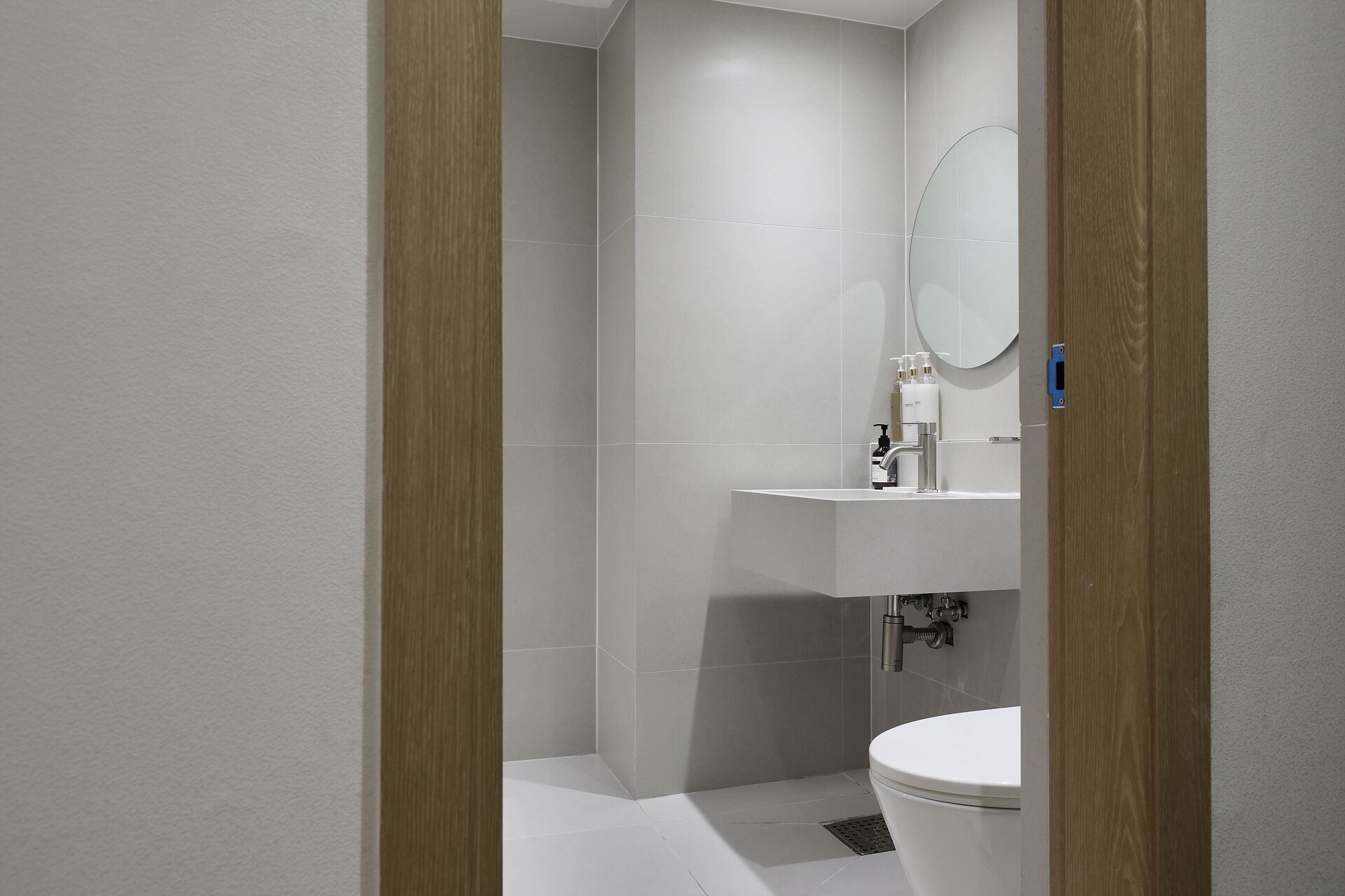 Une salle de bain moderne avec des toilettes, un lavabo et un miroir.