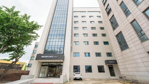 Moderni hotellirakennus, jonka huomiota herättävä julkisivu on suurimmaksi osaksi lasia, ja jossa on kyltti, jossa lukee: ”BROWN DOT HOTEL”.