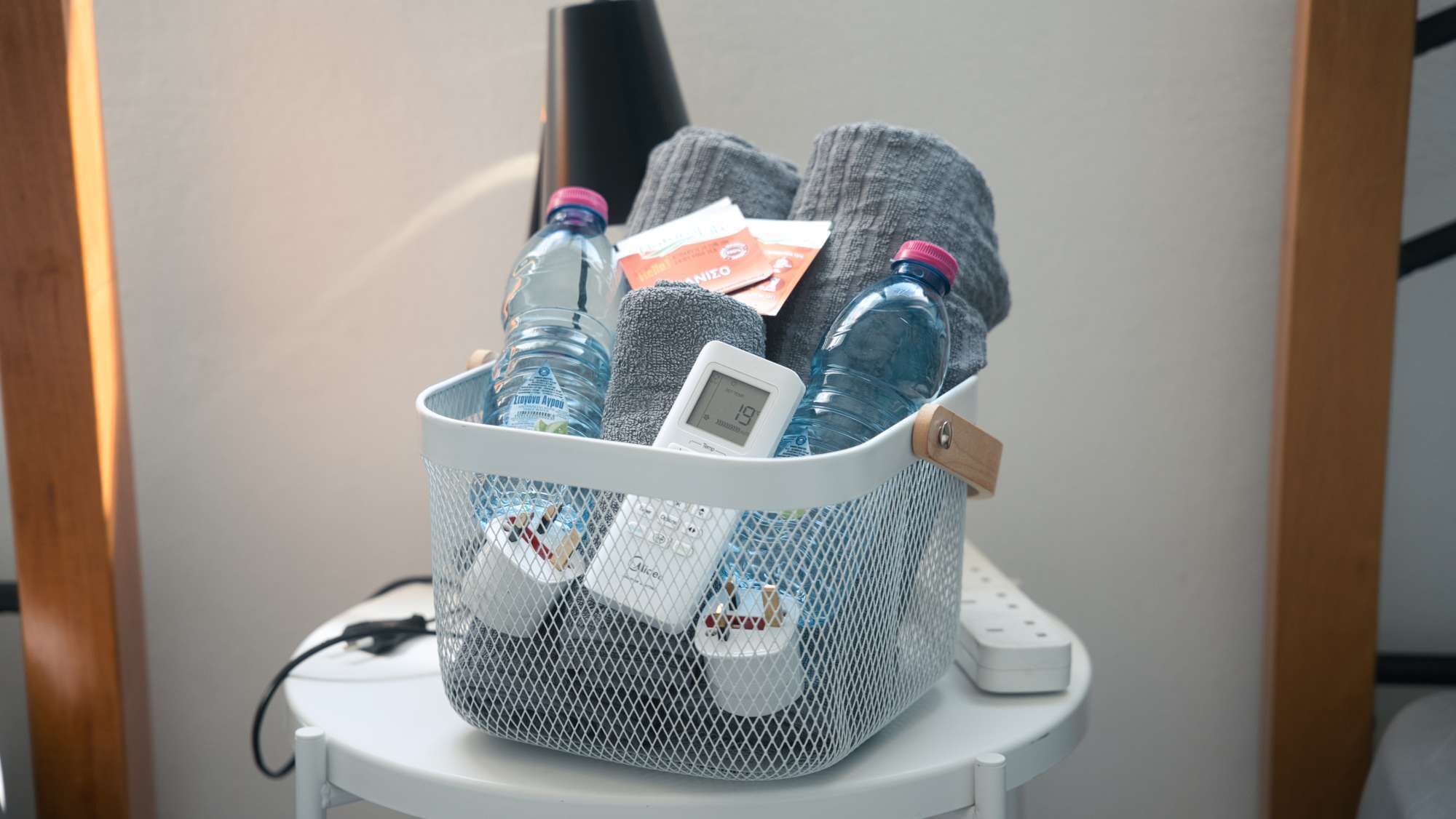 Un panier en filet contenant des bouteilles d’eau, un radiateur portable et une carte.