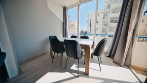 Une pièce moderne avec une grande fenêtre, une table en bois et quatre chaises.