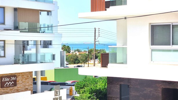 Ein modernes Mehrstöckige Gebäude mit Balkonen und Blick auf das Meer, mit einem Schild für 'Elite 204 Elite Island Properties'.