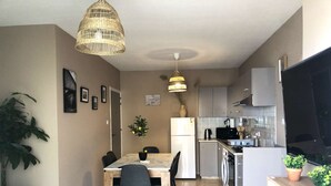 Una cucina compatta con zona pranzo, lavatrice e televisore.