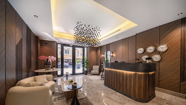 A modern lobby with a reception desk, seating area, and a unique ceiling light fixture. - SADEN-Alsalama (Jeddah)