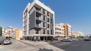 A modern multi-story building with a flat roof, large windows, and a parking lot in front. - SADEN-Alsalama (Jeddah)