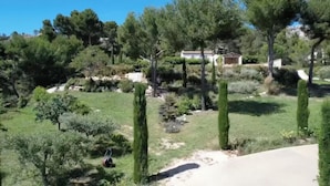 A residential area with a house surrounded by trees and a well-maintained lawn. - Mas les murmures (Les Baux-de-Provence)