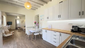 Eine moderne Küche mit weißen Schränken, einer Holz Arbeitsplatte und einer eingebauten Spüle.