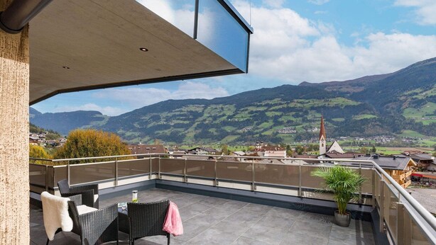Een balkon met uitzicht op een stad en bergen.