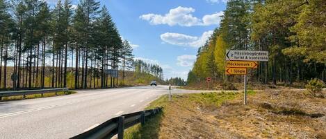 A road with a sign indicating Hässelbogårdens tourist and conference center, Möcklemark, and Sjögle.