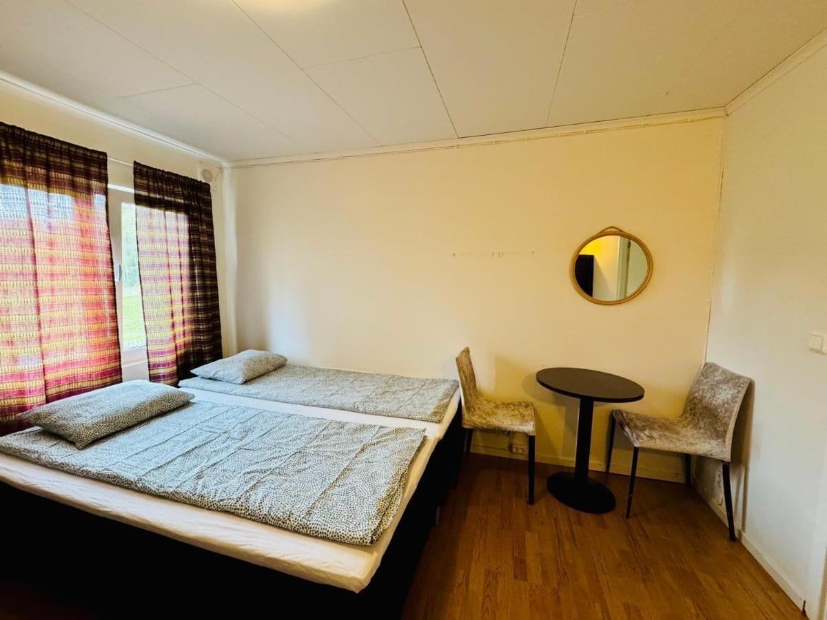 A room with two beds, a small round table, and two chairs.