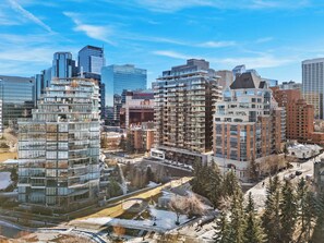 A modern urban skyline with high-rise buildings, including a prominent Rogers Centre. - City Sophistication w 2 BR River View, Parking, Office (Calgary)