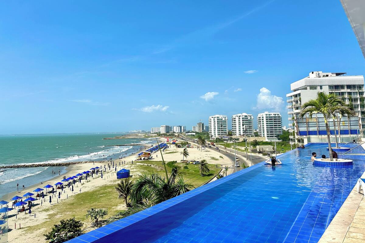 Um hotel com piscina de frente para uma praia e oceano.