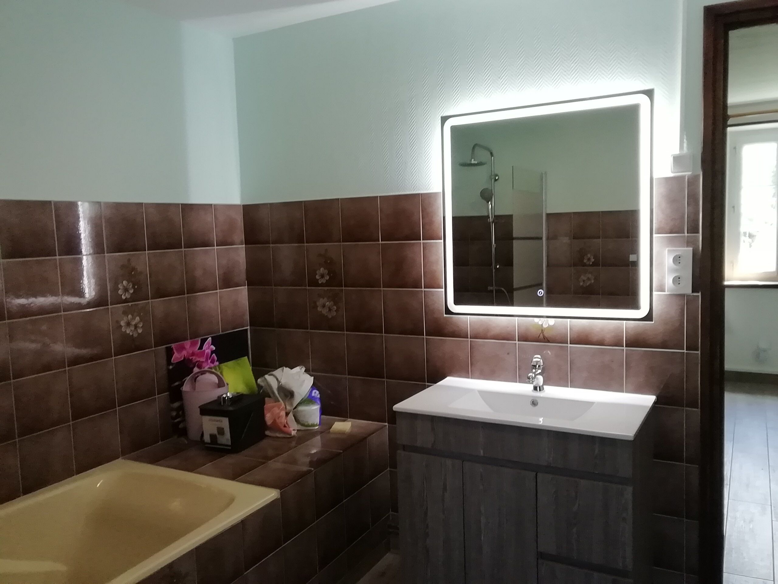 Une salle de bain avec une baignoire, un lavabo et un miroir.