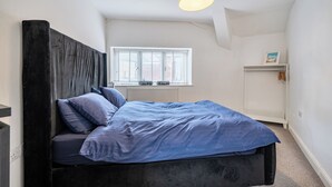 A bedroom with a bed, a window, a radiator, and a shelf. - Seaside Cottage Escape in Paignton - Sleeps 4 (Paignton)