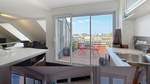 Una cocina moderna con un amplio ventanal corredero que da a un balcón.