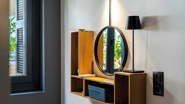 A wall-mounted wooden shelf with a mirror, a lamp, and a speaker. - Well Designed 1BR in Prime Kolonaki (Athina)