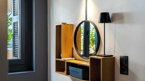 A wall-mounted wooden shelf with a mirror, a lamp, and a speaker.