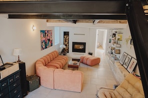 Ein modernes Wohnzimmer mit Ecksofa, Kamin und Bücherregal.