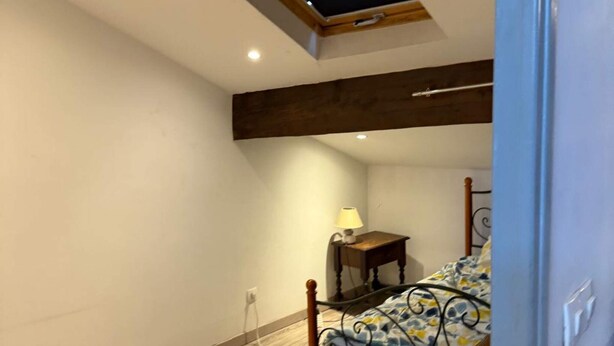 Una camera da letto con una cupola trasparente, un letto, un comodino con una lampada e un pavimento in legno.