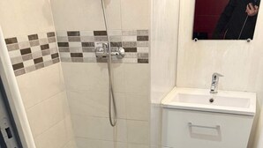 Un bagno piccolo con doccia, lavabo e WC.