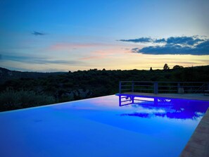A swimming pool with a view of a hilly landscape during sunset. - Villa Lenzo - Between nature and wonder (ferla)