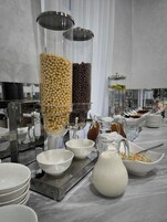 Montaje de bufé con diferentes dispensadores y recipientes de comida.